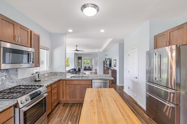 68-2182 Laakea Way, Waikoloa, HI 96738 - kitchen with appliances with stainless steel finishes, dark wood finished floors, a peninsula, light stone countertops, and recessed lighting