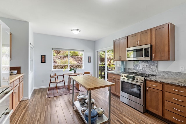 68-2182 Laakea Way, Waikoloa, HI 96738 - kitchen with stainless steel appliances, light wood-style floors, brown cabinets, and light stone countertops