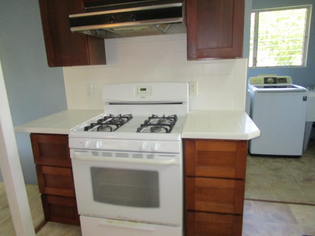 478 Hilinai St, Hilo, HI 96720 - kitchen with white gas stove, washer / clothes dryer, exhaust hood, light countertops, and tasteful backsplash