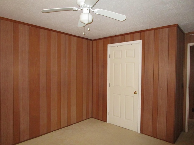 478 Hilinai St, Hilo, HI 96720 - unfurnished bedroom featuring carpet, a textured ceiling, crown molding, wooden walls, and a ceiling fan