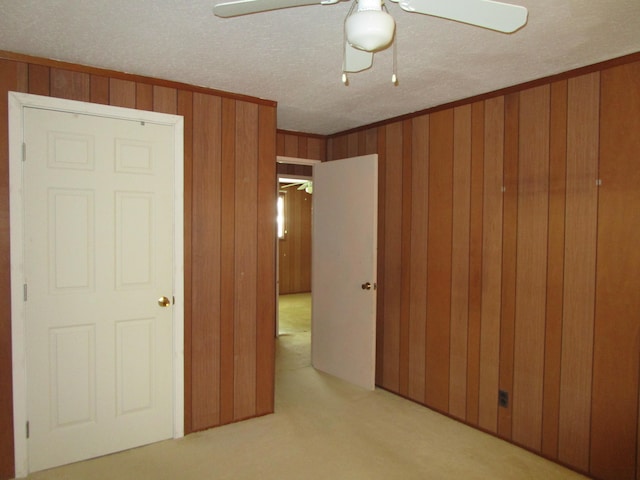 478 Hilinai St, Hilo, HI 96720 - unfurnished bedroom with light colored carpet, crown molding, wood walls, a ceiling fan, and a textured ceiling