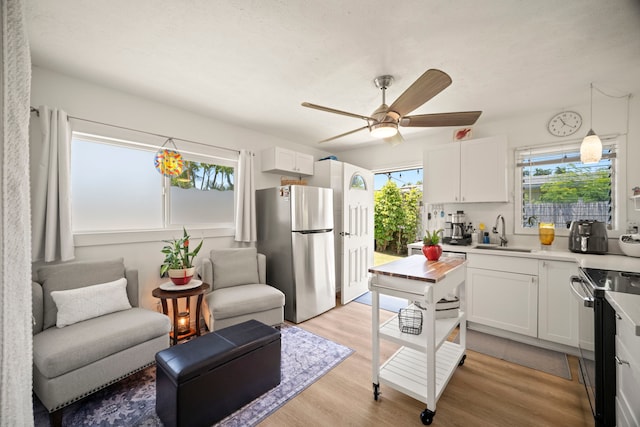 2375 Kipuka St, Koloa, HI 96756 - kitchen featuring freestanding refrigerator, black electric range, light wood finished floors, and white cabinets