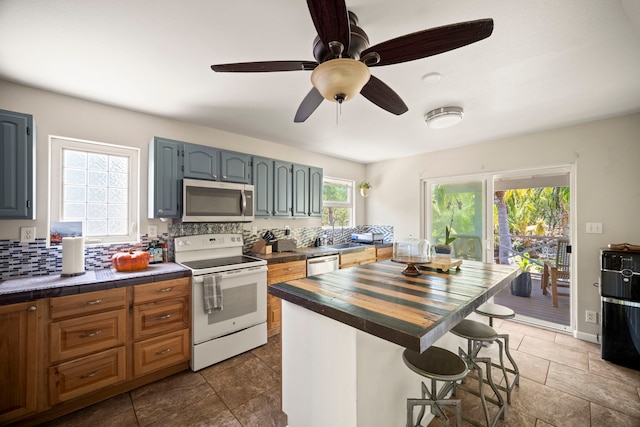 2375 Kipuka St, Koloa, HI 96756 - kitchen with appliances with stainless steel finishes, wood counters, decorative backsplash, a kitchen bar, and ceiling fan