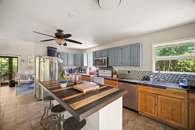 2375 Kipuka St, Koloa, HI 96756 - kitchen featuring appliances with stainless steel finishes, plenty of natural light, backsplash, and a ceiling fan