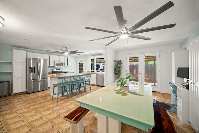 2375 Kipuka St, Koloa, HI 96756 - kitchen with appliances with stainless steel finishes, a ceiling fan, white cabinetry, and a kitchen island