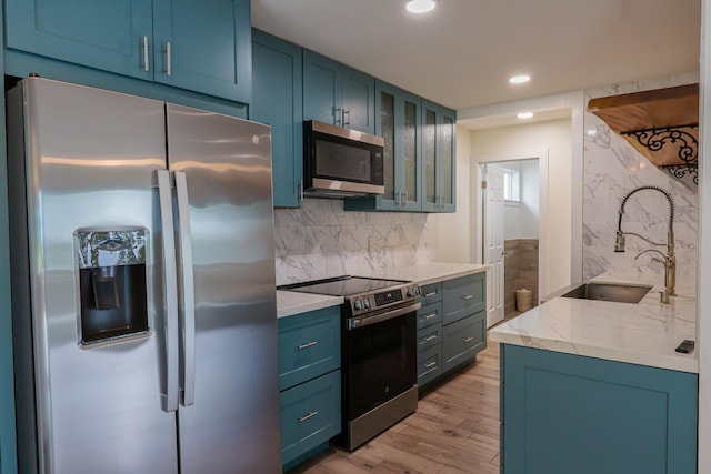 76-206 Kealoha St Unit 2A, Kailua-Kona, HI 96740 - kitchen featuring appliances with stainless steel finishes, blue cabinets, light wood-type flooring, recessed lighting, and tasteful backsplash