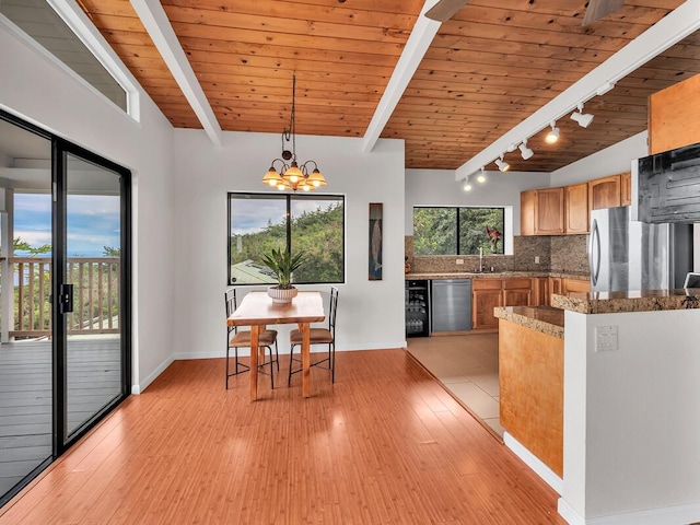 87-3216 Carissa Rd, Captain Cook, HI 96704 - kitchen featuring wine cooler, stainless steel dishwasher, freestanding refrigerator, decorative backsplash, and light wood-style flooring