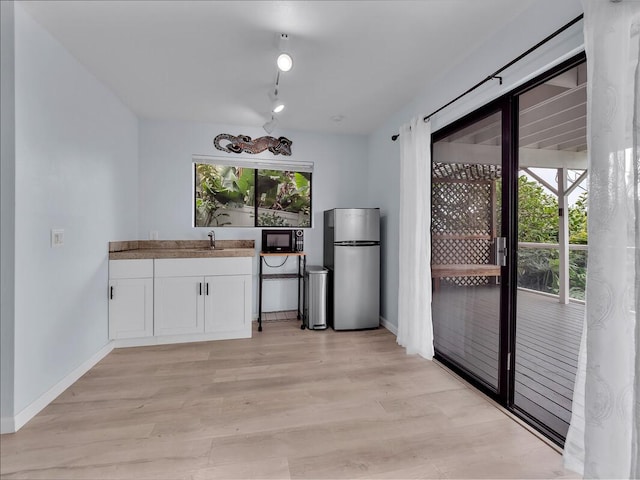 87-3216 Carissa Rd, Captain Cook, HI 96704 - kitchen with white cabinetry, light wood-style flooring, and black microwave
