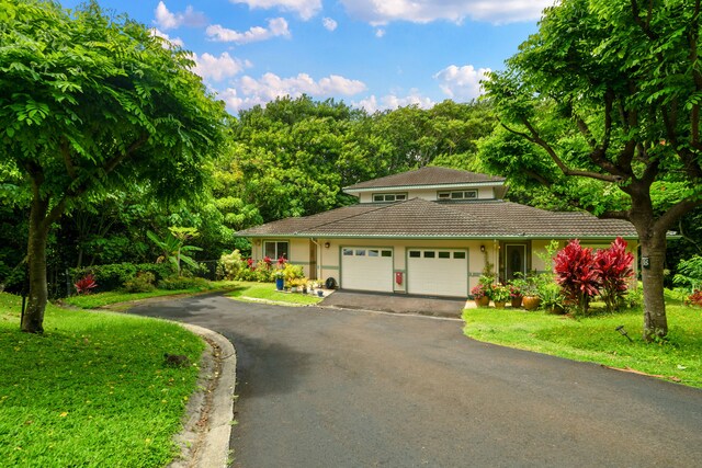 2110 Kaneka St Unit 46, Lihue, HI 96766 - view of front of house featuring asphalt driveway, a garage, stucco siding, and a front lawn