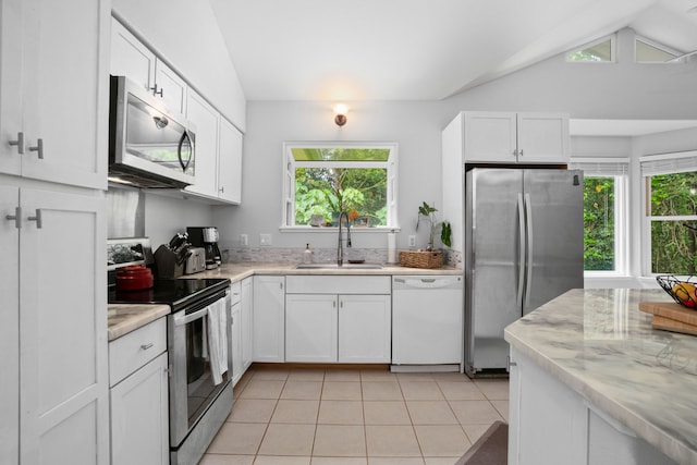2110 Kaneka St Unit 46, Lihue, HI 96766 - kitchen featuring stainless steel appliances, vaulted ceiling, white cabinets, light tile patterned flooring, and light stone counters