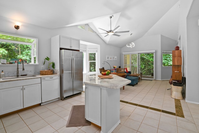 2110 Kaneka St Unit 46, Lihue, HI 96766 - kitchen with freestanding refrigerator, white dishwasher, light tile patterned floors, vaulted ceiling, and healthy amount of natural light