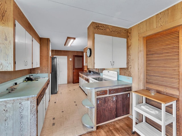 196 Iwalani St, Hilo, HI 96720 - kitchen with freestanding refrigerator, white electric range oven, wood walls, light countertops, and white cabinets