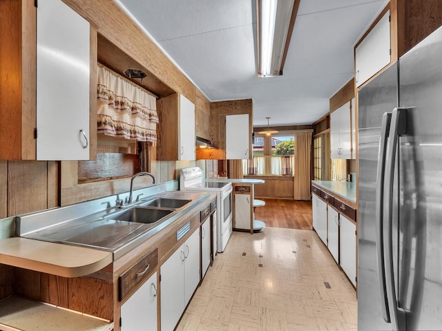 196 Iwalani St, Hilo, HI 96720 - kitchen featuring freestanding refrigerator, white range oven, white cabinetry, light flooring, and under cabinet range hood