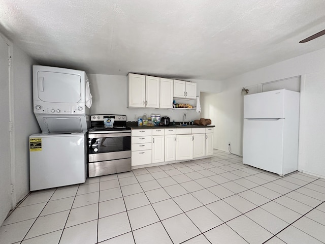 76-6303 Haku Pl, Kailua-Kona, HI 96740 - kitchen featuring freestanding refrigerator, stainless steel range with electric stovetop, stacked washer and clothes dryer, dark countertops, and open shelves