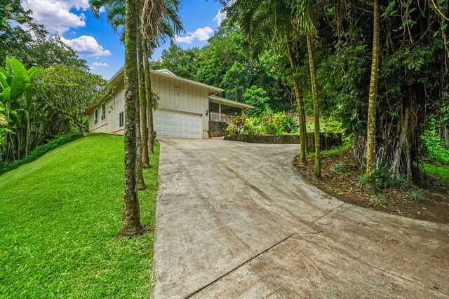 2895 Wawae Rd, Kalaheo, HI 96741 - view of home's exterior with an attached garage, driveway, a yard, and board and batten siding