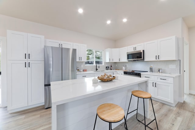 15-1713 32nd Ave, Keaau, HI 96749 - kitchen featuring stainless steel appliances, a kitchen bar, white cabinetry, a kitchen island, and light countertops