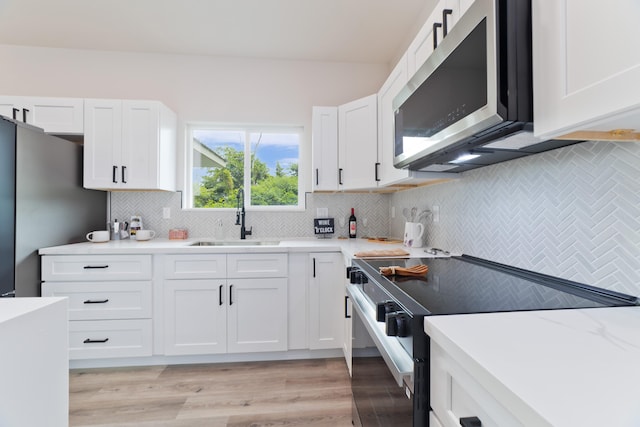 15-1713 32nd Ave, Keaau, HI 96749 - kitchen featuring electric stove, stainless steel microwave, white cabinetry, tasteful backsplash, and light wood-type flooring