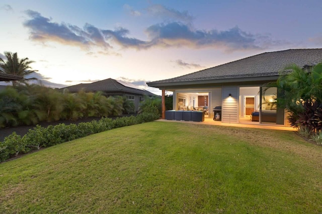 68-1122 Kaniku Dr Unit 426, Kamuela, HI 96743 - back of house at dusk with an outdoor hangout area and a yard