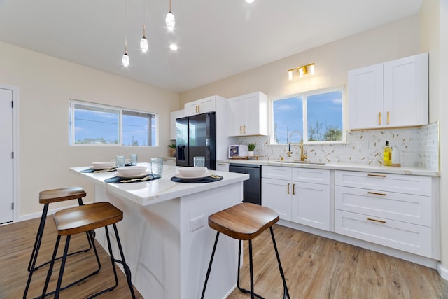 16-2102 Leilani Dr, Pahoa, HI 96778 - kitchen featuring black appliances, a center island, a breakfast bar, and decorative backsplash