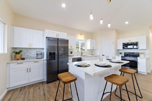 16-2102 Leilani Dr, Pahoa, HI 96778 - kitchen featuring appliances with stainless steel finishes, a kitchen bar, tasteful backsplash, and lofted ceiling