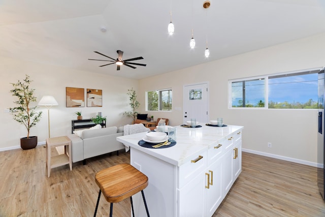 16-2102 Leilani Dr, Pahoa, HI 96778 - kitchen featuring white cabinets, light wood-style floors, a center island, and open floor plan