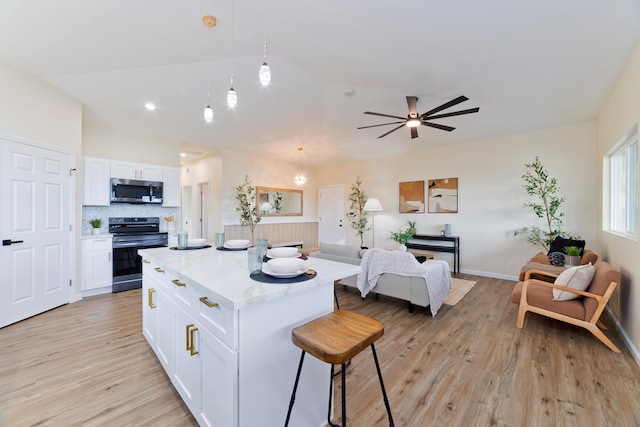 16-2102 Leilani Dr, Pahoa, HI 96778 - kitchen with range with electric cooktop, stainless steel microwave, a kitchen bar, white cabinetry, and open floor plan
