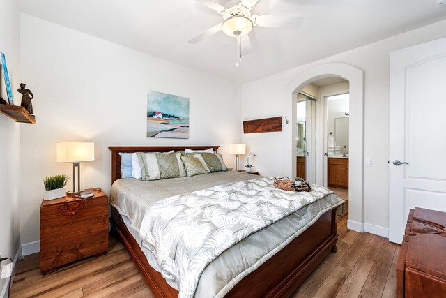 75-5919 Alii Dr Unit M3, Kailua-Kona, HI 96740 - bedroom featuring arched walkways, light wood-style floors, ensuite bathroom, and a ceiling fan