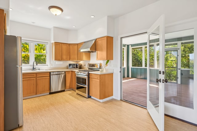 2645 Keoki Pl, Kalaheo, HI 96741 - kitchen with appliances with stainless steel finishes, wall chimney range hood, light countertops, light wood-style flooring, and recessed lighting