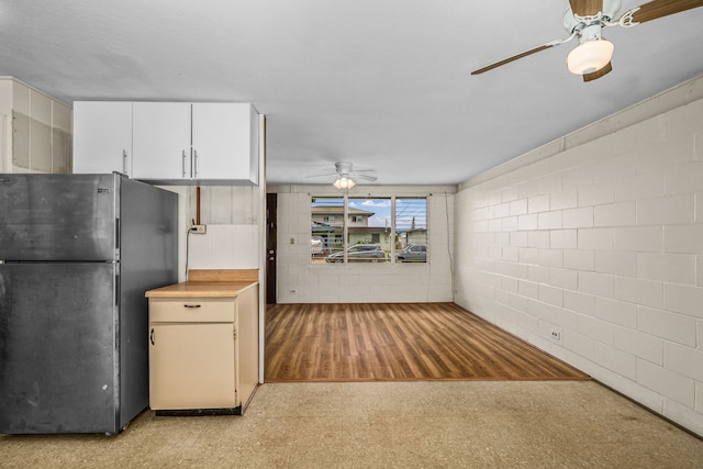 3878 Mamaki St, Koloa, HI 96756 - kitchen featuring freestanding refrigerator, a ceiling fan, light countertops, concrete block wall, and white cabinets