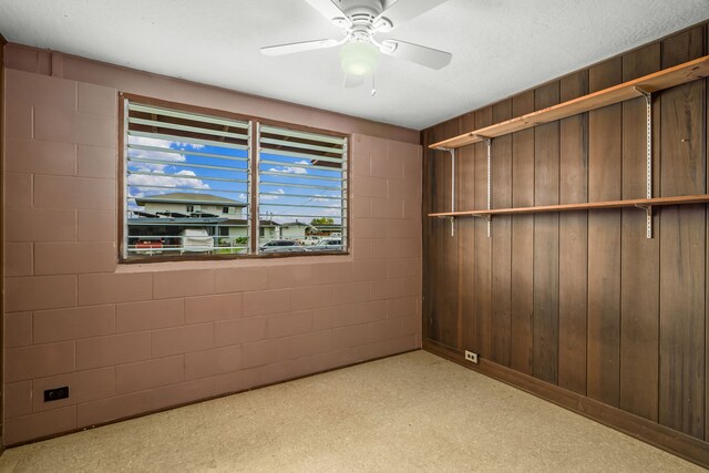 3878 Mamaki St, Koloa, HI 96756 - unfurnished bedroom with light carpet, concrete block wall, wooden walls, and a ceiling fan