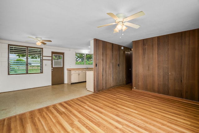 3878 Mamaki St, Koloa, HI 96756 - unfurnished living room with ceiling fan, wood walls, and light wood-type flooring