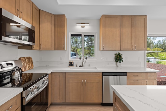 16-2072 Kuhio Dr, Pahoa, HI 96778 - kitchen with stainless steel appliances, light stone countertops, brown cabinetry, and light wood-type flooring
