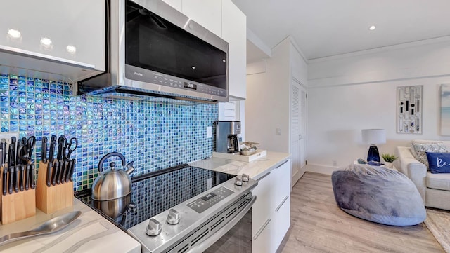 2253 Poipu Rd Unit 216, Koloa, HI 96756 - kitchen featuring appliances with stainless steel finishes, white cabinetry, backsplash, modern cabinets, and light wood-style floors