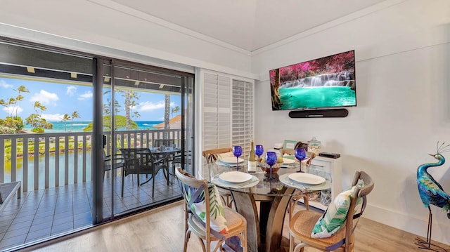 2253 Poipu Rd Unit 216, Koloa, HI 96756 - dining room featuring wood finished floors, a water view, and ornamental molding