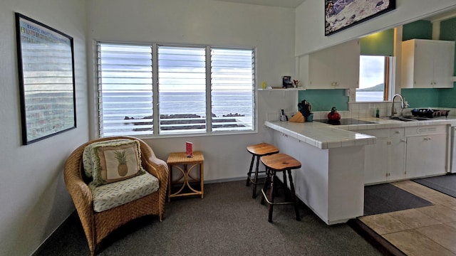 82-6047 Puuhonua Rd, Captain Cook, HI 96704 - kitchen with tile countertops, white cabinetry, black electric cooktop, and light carpet