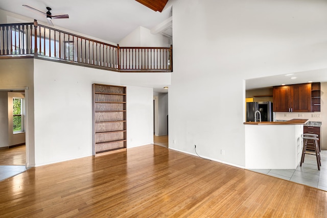 79-1145 Kao Rd, Holualoa, HI 96725 - unfurnished living room with high vaulted ceiling, a ceiling fan, and light wood-style floors