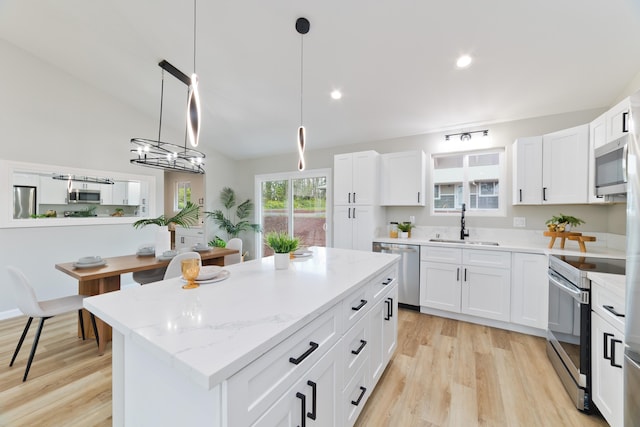 16-2148 Pukalani Dr, Pahoa, HI 96778 - kitchen with stainless steel appliances, light wood-style floors, white cabinetry, vaulted ceiling, and recessed lighting