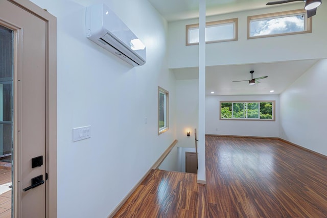4417-B Kahili Makai St Unit D, Kilauea, HI 96754 - unfurnished living room with a wall unit AC, wood finished floors, ceiling fan, and a high ceiling