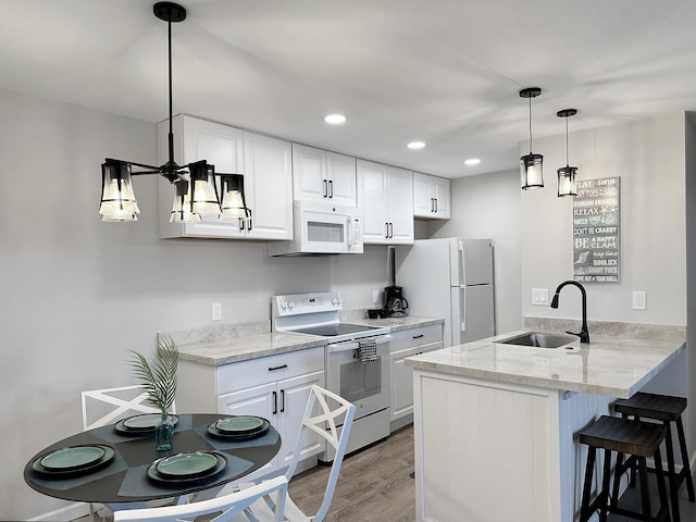 68-3831 Lua Kula St Unit H202, Waikoloa, HI 96738 - kitchen featuring white appliances, a peninsula, light wood-type flooring, a breakfast bar area, and white cabinetry