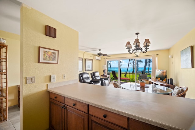 4-1250 Kuhio Hwy Unit G204, Kapaa, HI 96746 - kitchen featuring open floor plan, brown cabinetry, a chandelier, pendant lighting, and a textured wall