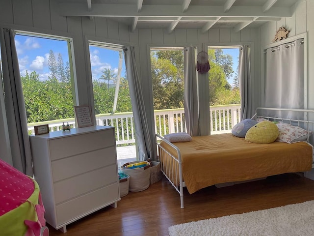 94-5868 Kanaloa Pl, Naalehu, HI 96772 - bedroom featuring wood-type flooring, beam ceiling, access to outside, and a decorative wall