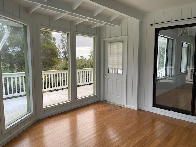 94-5868 Kanaloa Pl, Naalehu, HI 96772 - doorway to outside with wood finished floors, beam ceiling, plenty of natural light, a decorative wall, and a chandelier