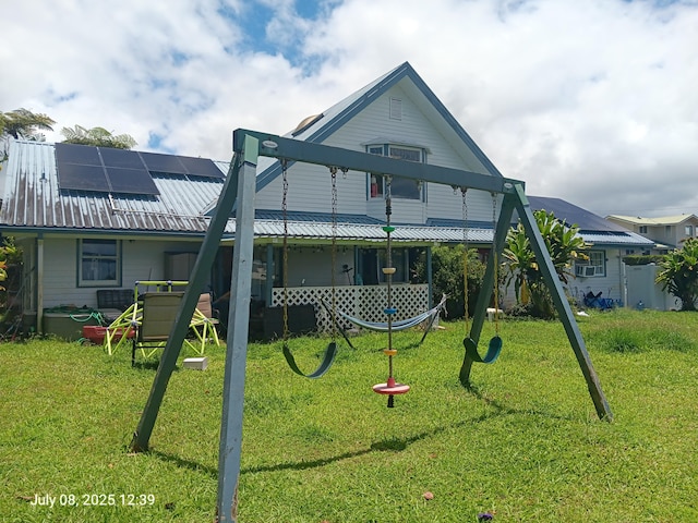 433 Kaanini St, Hilo, HI 96720 - back of property featuring solar panels, a metal roof, and a lawn