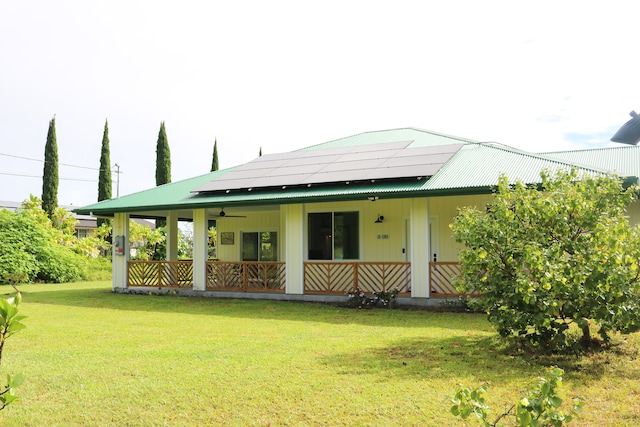 15-1393 29th Ave, Keaau, HI 96749 - back of property with ceiling fan, roof mounted solar panels, a lawn, and a metal roof