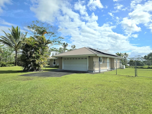 15-1581 Railroad Ave, Keaau, HI 96749 - view of front of property with roof mounted solar panels, an attached garage, driveway, and board and batten siding