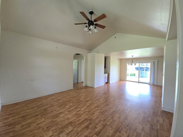 15-1581 Railroad Ave, Keaau, HI 96749 - unfurnished living room featuring a ceiling fan, wood finished floors, arched walkways, a chandelier, and high vaulted ceiling
