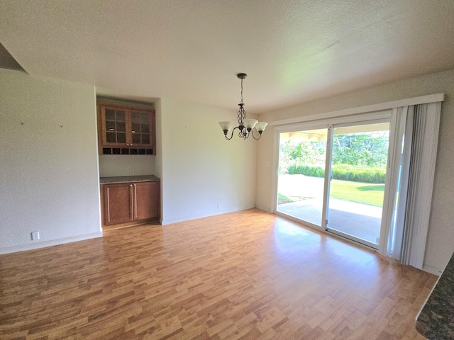 15-1581 Railroad Ave, Keaau, HI 96749 - spare room featuring a chandelier, light wood-style flooring, and a textured ceiling