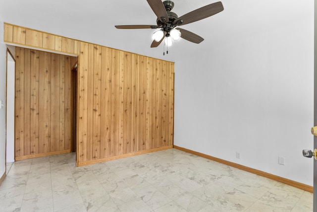 13-3401 Alapai St, Pahoa, HI 96778 - empty room featuring light marble finish floors, wood walls, and ceiling fan