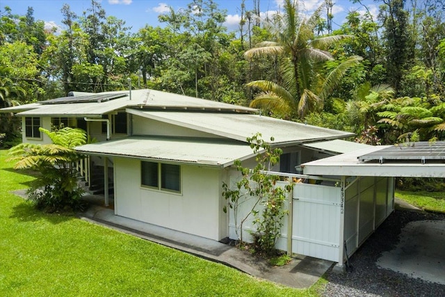 14-3342 Kaululaau Rd Unit 3, Pahoa, HI 96778 - view of property exterior featuring a lawn and a carport