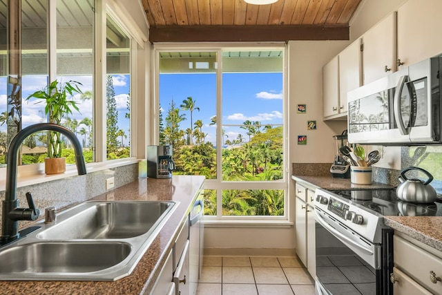 3811 Edward Rd Unit 3304, Princeville, HI 96722 - kitchen featuring appliances with stainless steel finishes, wood ceiling, plenty of natural light, light tile patterned floors, and white cabinetry
